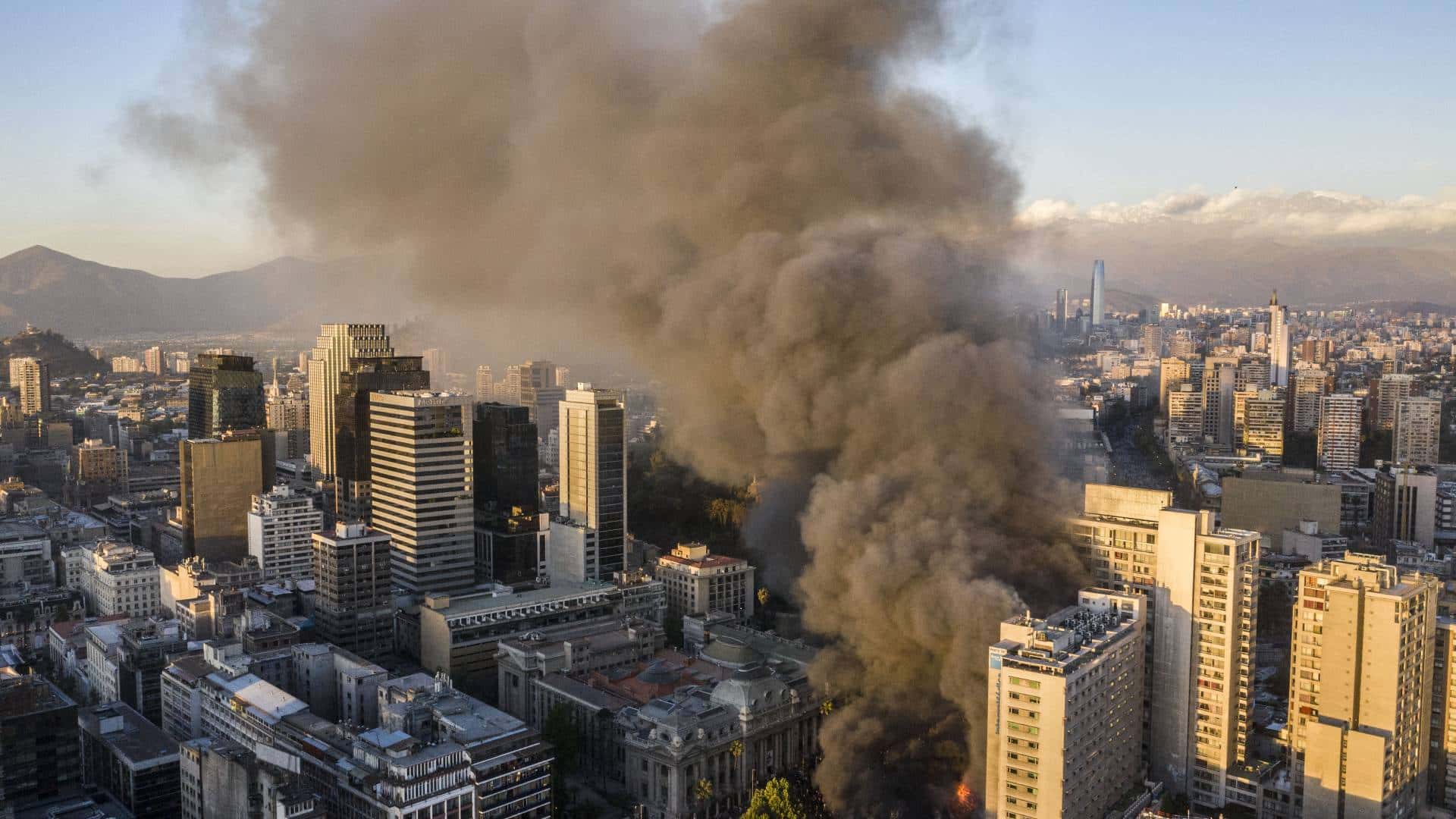 Edificios comerciales incendiandose en la Alameda como producto de ataques incendiarios de manifestantes